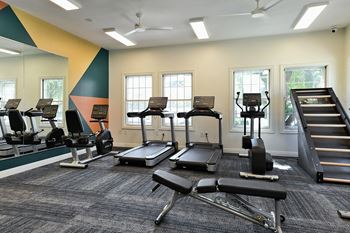 A gym with treadmills, elliptical machines, and a stair climber.